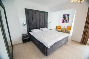 a bedroom with a large bed with a large headboard at Alessio Hotel Residence in Costinesti