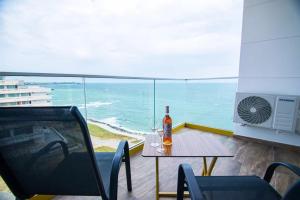 - une table avec une bouteille de vin sur un balcon donnant sur l'océan dans l'établissement Alessio Hotel Residence, à Costinesti