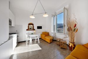 eine Küche und ein Wohnzimmer mit einem Tisch und einem Sofa in der Unterkunft Casa Francesca in Levanto