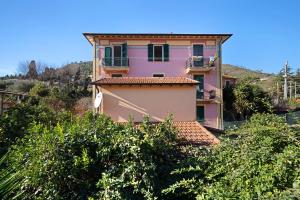 ein rosa Haus auf einem Hügel mit Bäumen in der Unterkunft Casa Francesca in Levanto