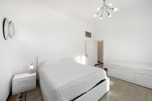ein weißes Schlafzimmer mit einem Bett und einer Kommode in der Unterkunft Casa Francesca in Levanto