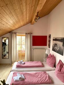 two beds in a room with red and white pillows at Appartement Aldea in Bad Aibling