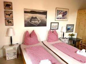 Cette chambre comprend 2 lits avec des oreillers rouges et blancs. dans l'établissement Appartement Aldea, à Bad Aibling