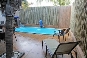 a swimming pool with chairs and a palm tree at JS Thermas Hotel in Olímpia