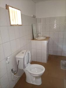 La salle de bains est pourvue de toilettes blanches et d'un lavabo. dans l'établissement CAMPEMENT DIAMORAL DIAKENE OULOFF, à Diakène Ouolof