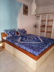 a bedroom with a bed with a blue comforter at CAMPEMENT DIAMORAL DIAKENE OULOFF in Diakène Ouolof