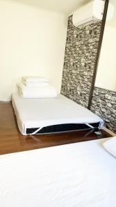two beds in a room with a stone wall at 花乃郷 赤羽 in Tokyo