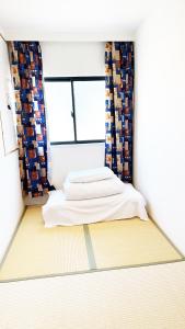 a small room with a bed and a window at 花乃郷 赤羽 in Tokyo