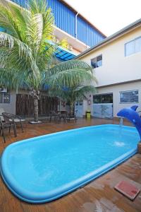 una gran piscina con una fuente de delfines en un edificio en JS Thermas Hotel, en Olímpia