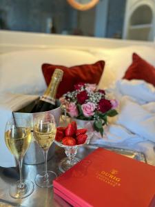 ローザンヌにあるカールトン ローザンヌ ブティック ホテルのワイン1本、ワイングラス、イチゴを用意したテーブル