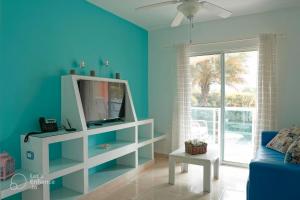 a living room with a tv and a blue wall at Ria Aparta Hotel in San Felipe de Puerto Plata