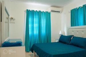 a bedroom with blue curtains and a blue bed at Ria Aparta Hotel in San Felipe de Puerto Plata