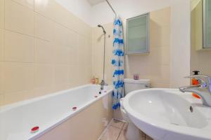 een badkamer met een bad, een wastafel en een toilet bij Modern Living in the Heart of Covent Garden! 6BC in Londen