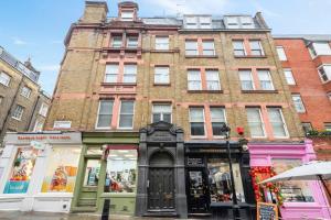 ein großes Backsteingebäude in einer Straße mit Geschäften in der Unterkunft Modern Living in the Heart of Covent Garden! 6BC in London