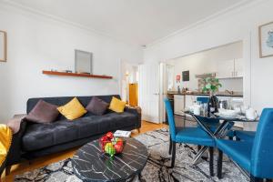 ein Wohnzimmer mit einem schwarzen Sofa und einem Tisch in der Unterkunft Modern Living in the Heart of Covent Garden! 6BC in London
