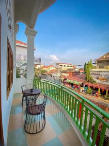 einen Balkon mit einem Tisch und Blick auf einen Zug in der Unterkunft CENTRO GUEST HOUSE in Siem Reap