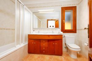 a bathroom with a sink and a toilet and a mirror at Chalet Mirador 3A in Alcanada +16 photos