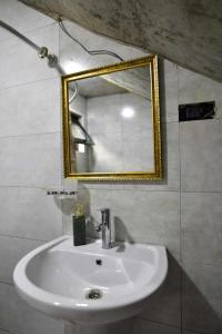 W łazience znajduje się biała umywalka i lustro. w obiekcie BORJOMI CHALET WEEKEND w mieście Tsemi