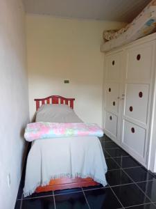 Casa Delicia em Passa Quatro Até 4 pessoas في باسا كواترو: غرفة نوم صغيرة مع سرير وخزانة