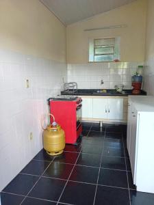 uma cozinha com um fogão vermelho e uma panela amarela em Casa Delicia em Passa Quatro Até 4 pessoas em Passa Quatro
