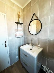 a bathroom with a sink and a mirror at Merveilleux appartement style nature proche centre ville in Collioure