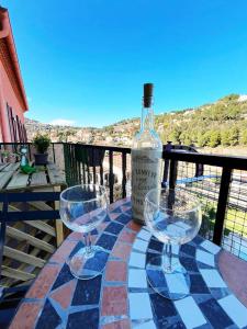 una botella de vino sentada en una mesa con dos copas de vino en Merveilleux appartement style nature proche centre ville en Collioure