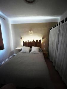 a bedroom with a large bed with white pillows at Merveilleux appartement style nature proche centre ville in Collioure