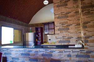 cocina con pared de ladrillo y nevera en Kony Nubian Guest House, en Abu Simbel