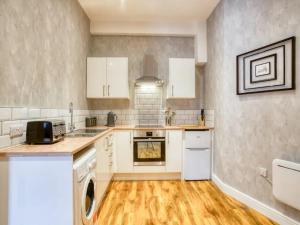 a kitchen with white cabinets and a washer and dryer at Pass the Keys Contemporary Flat City Centre in Lincoln