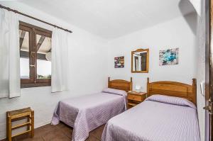 a room with two beds and a window at Villa Bini Aida in Sant Lluis +13 photos