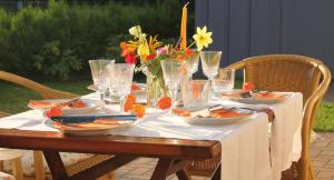 a table with plates and glasses and flowers on it at Ferienhaus Laran in Zingst +22 photos