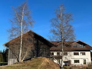 un granero con dos árboles delante de una casa en Haus Allgäu Ruh, en Görisried