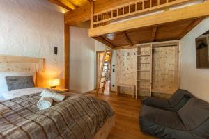 een slaapkamer met een bed en een stoel in een kamer bij Alprocks Alvaresort in Bichlbach