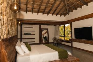 Schlafzimmer mit einem Bett und einem Flachbild-TV in der Unterkunft Hotel El Cielo en la Tierra in Alcalá