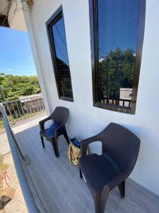 a balcony with two chairs and a mirror on a house at Balai ni Gemma – cozy studio near airport in General Santos