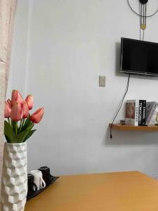 un vase avec des fleurs roses assises sur une table dans l'établissement Balai ni Gemma – cozy studio near airport, à General Santos