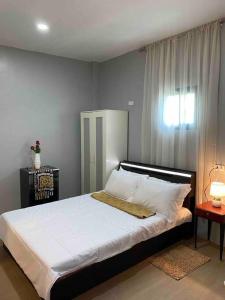 - une chambre avec un grand lit blanc et une fenêtre dans l'établissement Balai ni Gemma – cozy studio near airport, à General Santos