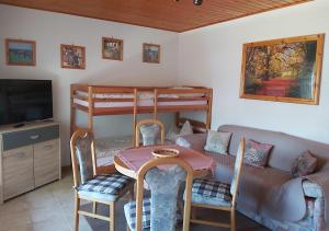 ein Wohnzimmer mit einem Tisch, Stühlen und einem Sofa in der Unterkunft Gasthof und Eiscafe Frank in Leimbach