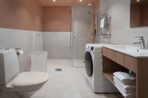 a bathroom with a toilet and a sink and a washing machine at Sky Hotel Apartments, Stockholm in Stockholm +37 photos
