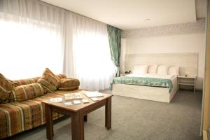 a hotel room with a bed and a couch at Bulvar Inn Baku Hotel in Baku