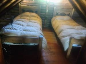 two twin beds in a room with at CABAÑA EN EL MANZANO HISTORICO in Los Árboles