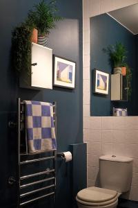 uma casa de banho com WC e fotografias na parede em Sunny Shoreditch Oasis Canal Views & Urban Charm em Londres