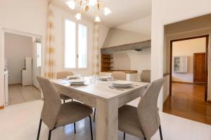 フィレンツェにあるSanto Spirito Exclusive Apartmentのキッチン、ダイニングルーム(テーブル、椅子付)