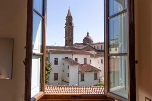 ein offenes Fenster mit Stadtblick in der Unterkunft Santo Spirito Exclusive Apartment in Florenz