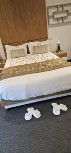 a bedroom with a bed with two pairs of slippers at Guesthaus 1 in Dudelange