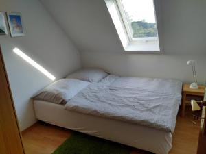 uma pequena cama num quarto com uma janela em Ferienwohnung 1 Schulze em Neustrelitz