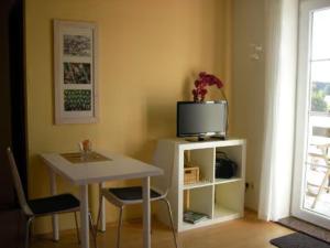 um quarto com uma mesa e uma televisão na parede em Ferienwohnung 1 Schulze em Neustrelitz