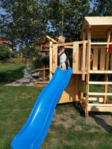 a boy on a slide in a play house at Ferienwohnung 2 Schulze in Neustrelitz