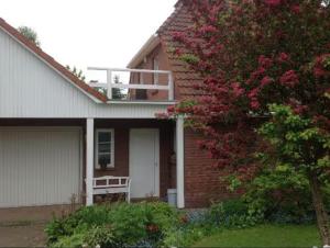 施特雷利茨的住宿－Ferienwohnung 2 Schulze，带阳台的房子和一棵带粉红色花卉的树