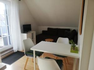 施特雷利茨的住宿－Ferienwohnung 2 Schulze，一间小客厅,配有白色的桌子和椅子